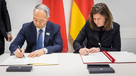 Parlamentarische Staatssekretärin Dr. Ophelia Nick und der chinesische Vizeminister MA Youxiang sitzen am Tisch und unterzeichnen ein Dokument.