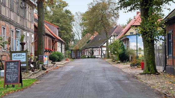 Straße im Dorf, gesäumt von Fachwerkhäusern.